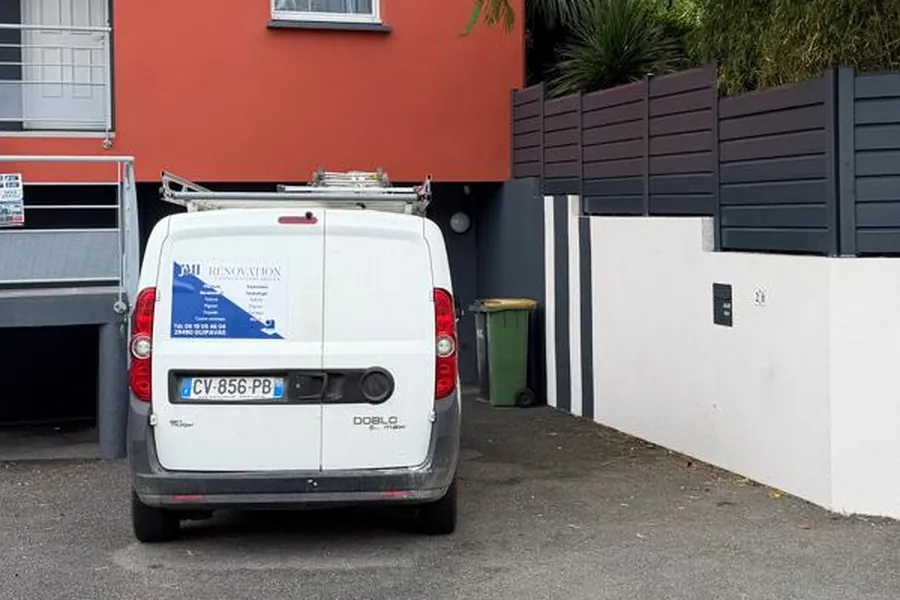 L'utilitaire floqué JMI Rénovation garé devant un chantier de peinture extérieure